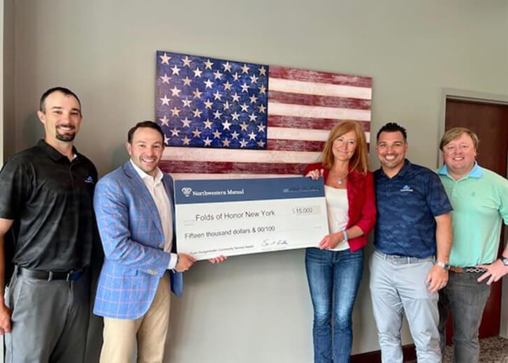 Spring Street Financial team holding a giant check for $15,000 for the Folds of Honor New York 